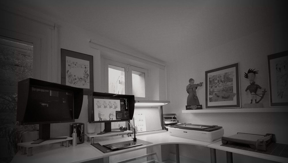 Poste de photogravure avec écrans calibrés, scanner et planches de bande dessinée encadrées